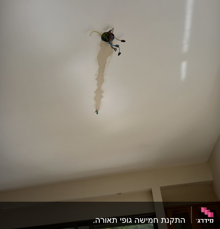 חוטי חשמל חשופים בתקרה עם חור